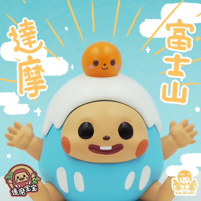 A close-up of Mount Fuji Dharma Baby toy by Kai, featuring a smiling cartoon character with arms and hands.